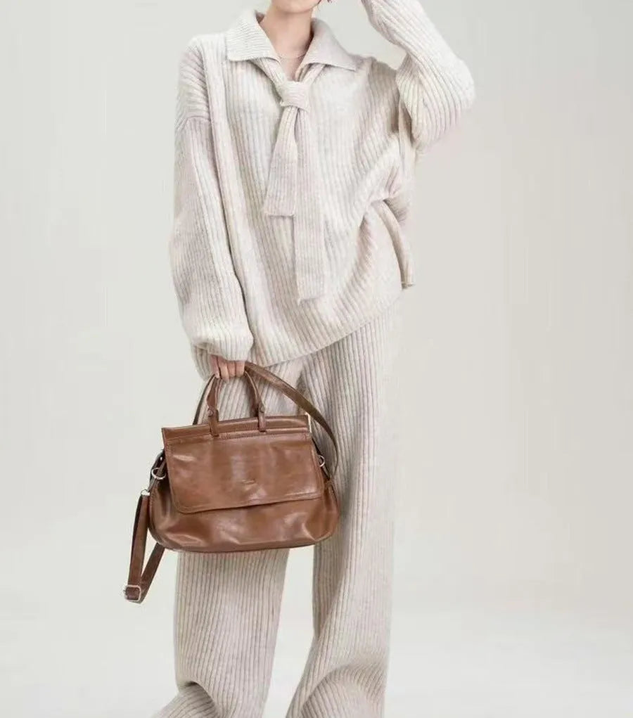 Women's beige knitted top and trousers two-piece set with long sleeves on a hanger.