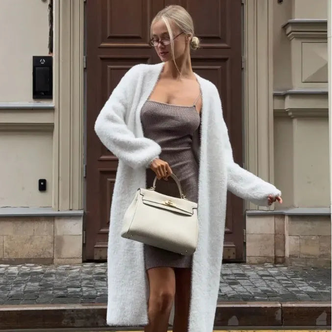 White oversized women's knit cardigan jacket with long line and regular sleeves.