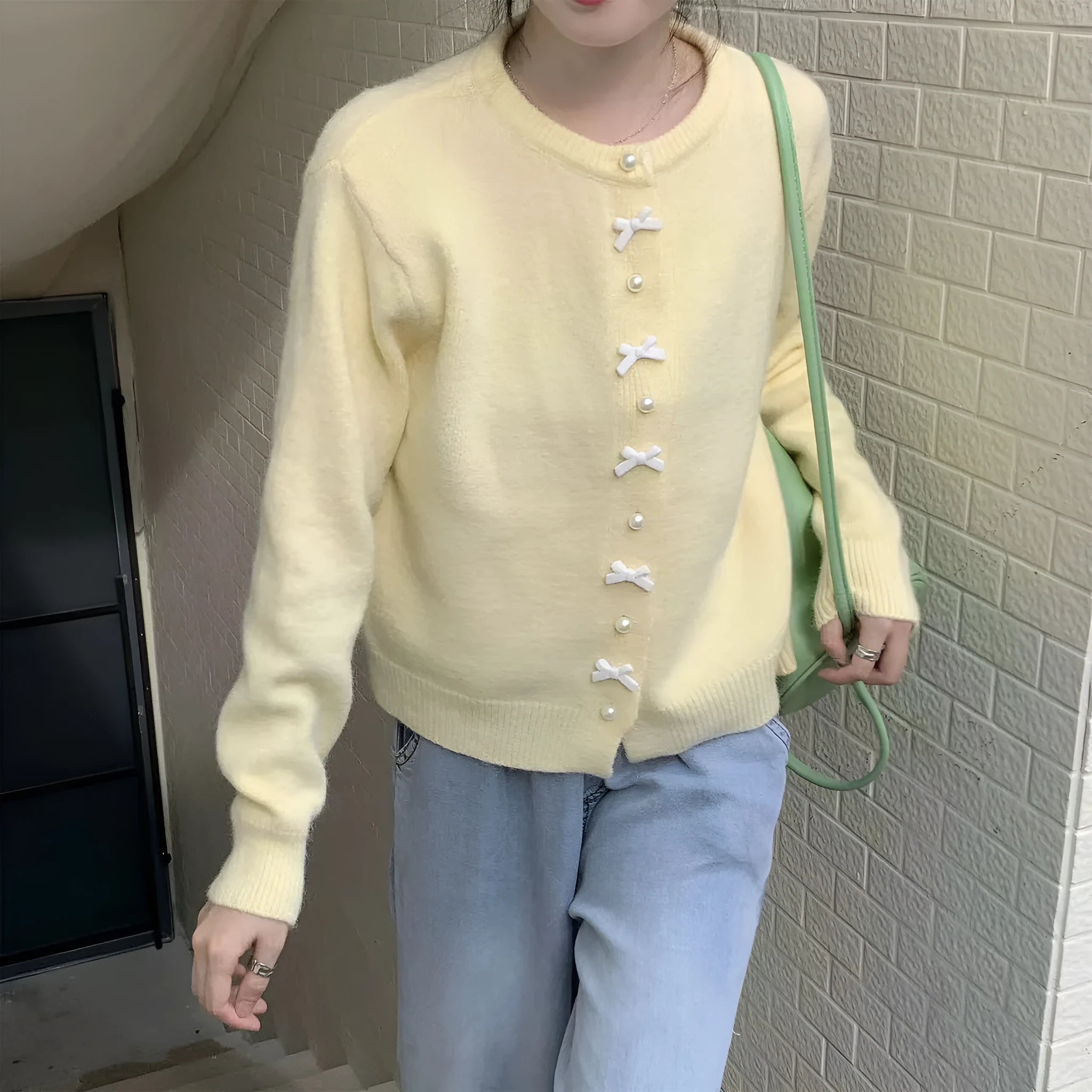 Women's light blue cashmere blend cardigan sweater with a bow and pearl buttons.