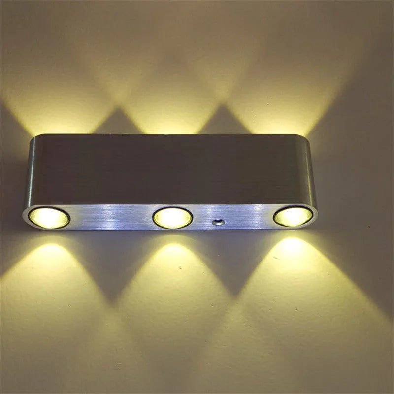 Silver aluminium rectangular LED wall lamp showing seven light colour options including blue, green, and warm white