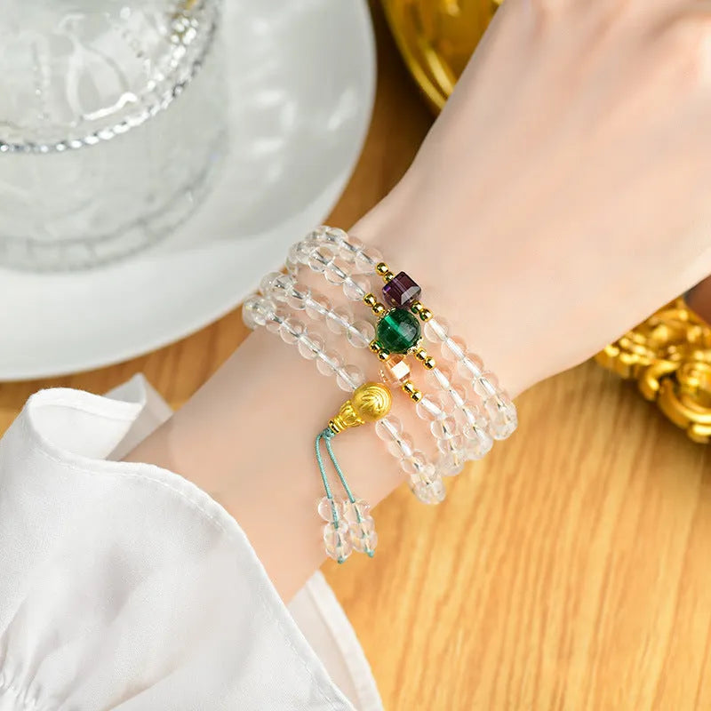 White crystal 108-bead rosary necklace and matching bracelet set on a plain background