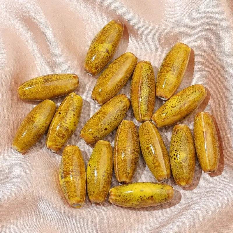 Assorted high-temperature fired ceramic bullet beads in pink, yellow, blue, red, coffee, green, orange, and mixed glaze colours.