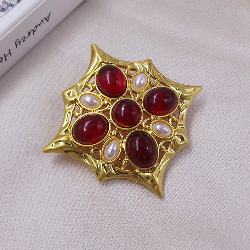 Close-up of vintage medieval baroque cross brooch with crystal accents on zinc alloy.