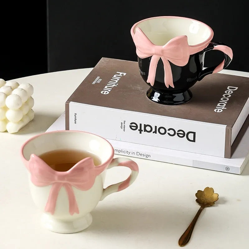 Ceramic mug with heart bow design in black pink and white powder colour options