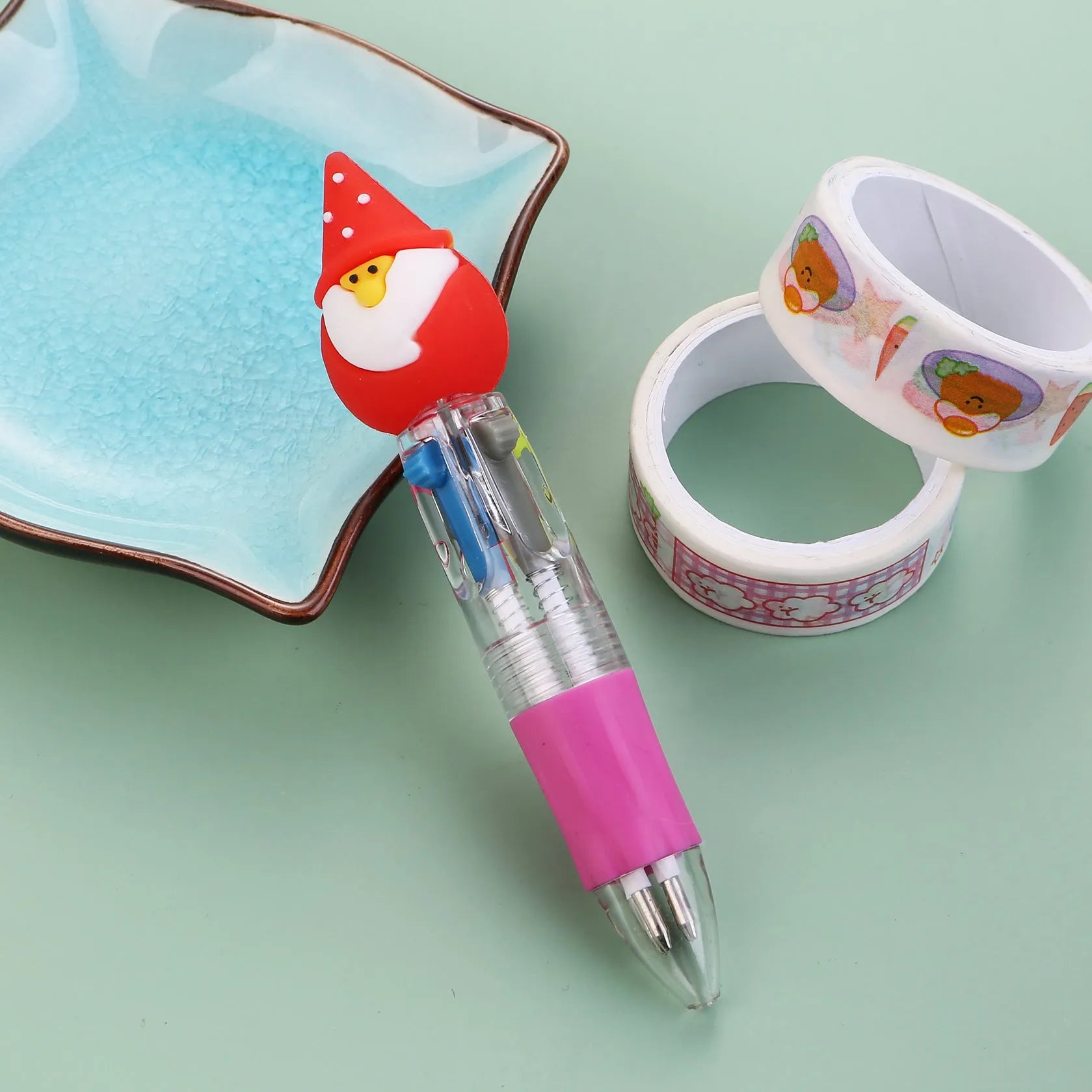 Compact 11cm Christmas ballpoint pen with four colours and festive designs like snowmen and reindeer.