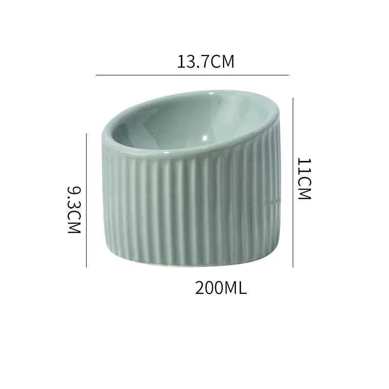 Ceramic elevated cat food bowl in green, showing tilted round dish on a raised stand.