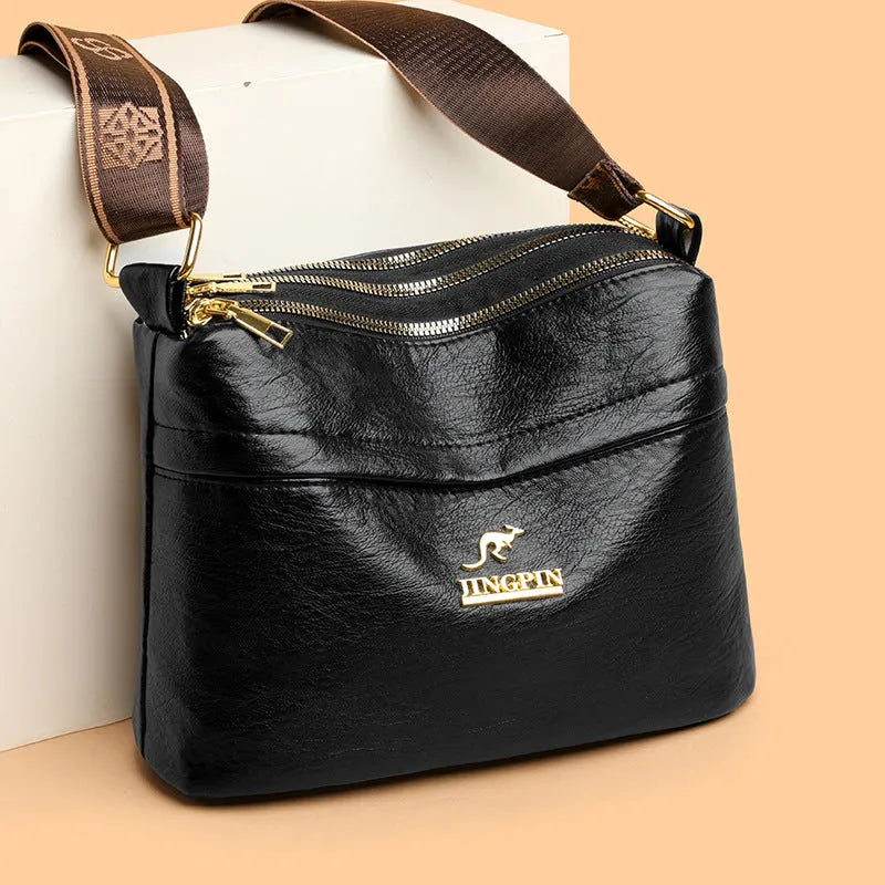 Brown cross body messenger bag with multiple compartments and sewing thread details on PU material