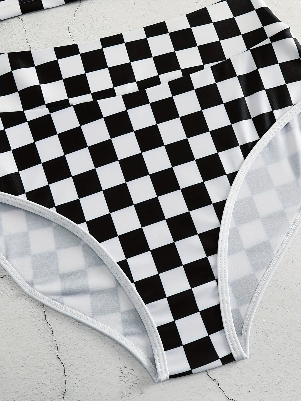 Women's black and white checkerboard plaid backless racing swimsuit with suspender straps.