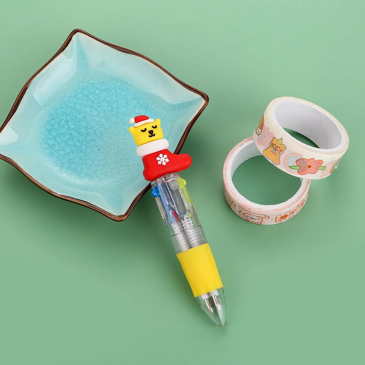 Compact 11cm Christmas ballpoint pen with four colours and festive designs like snowmen and reindeer.