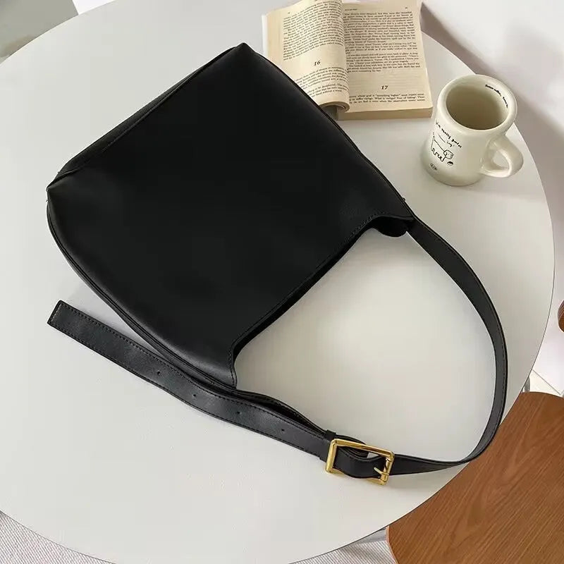 Women's soft PU shoulder bag with tassel detail in black and brown colour options