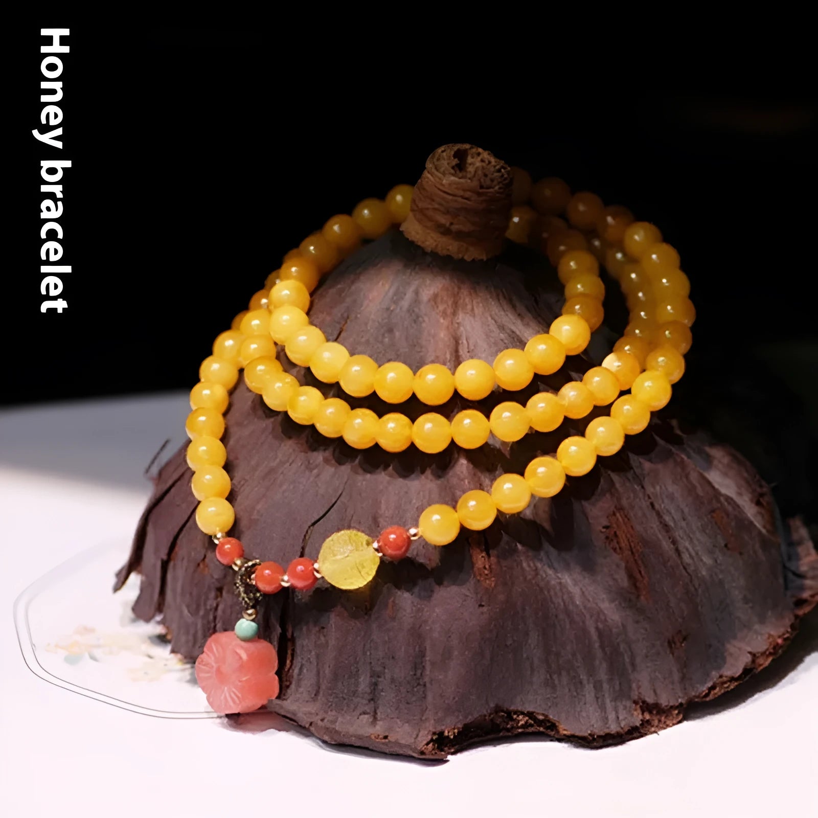 Close-up of a women's amber bracelet with animal modelling on round 5mm beads.