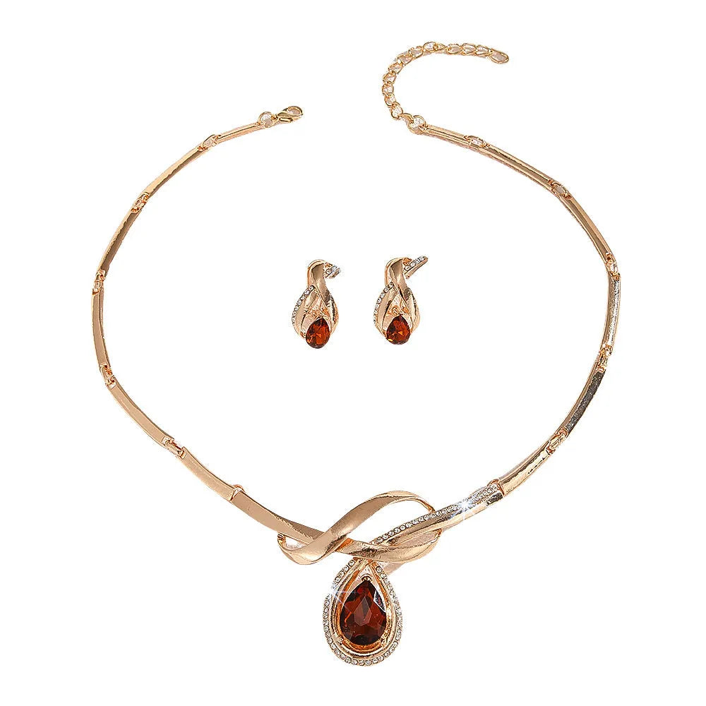 Gold alloy necklace and earrings suite with white rhinestone and brown crystal fan-shaped centrepiece on a white background