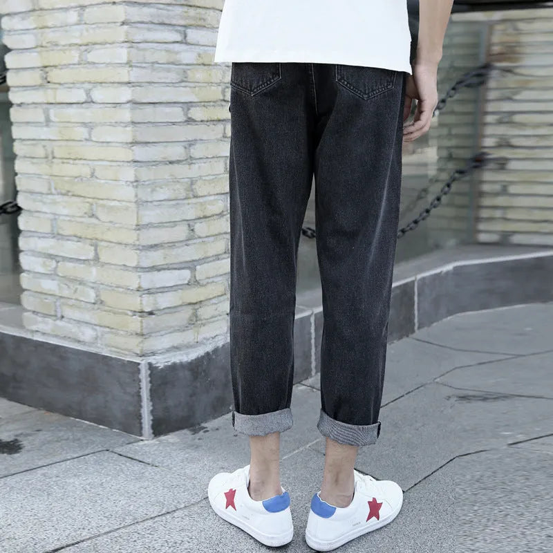 Men's loose straight-leg high-waisted harem jeans in black, laid flat.