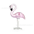 Pink crystal flamingo decorative ornament on a table for modern home decor.
