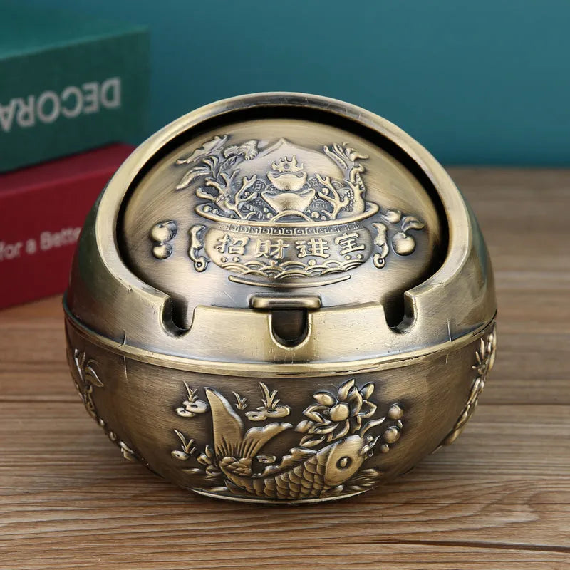 Bronze and red copper alloy decorative ashtray with smoke-extinguishing slot on a table.