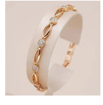 Golden coloured hollow carved copper bracelet with a U-shaped bangle profile on a white background.