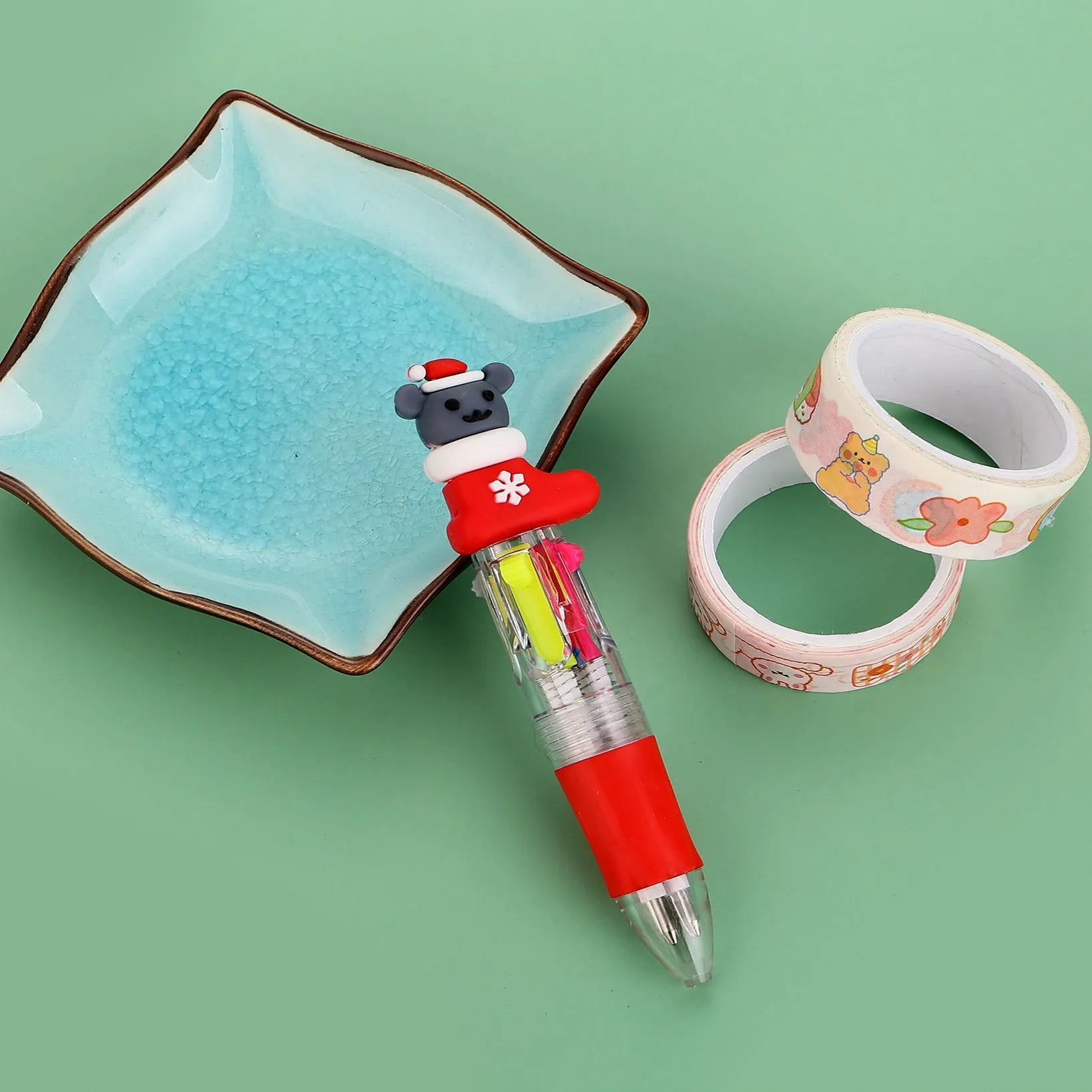 Compact 11cm Christmas ballpoint pen with four colours and festive designs like snowmen and reindeer.