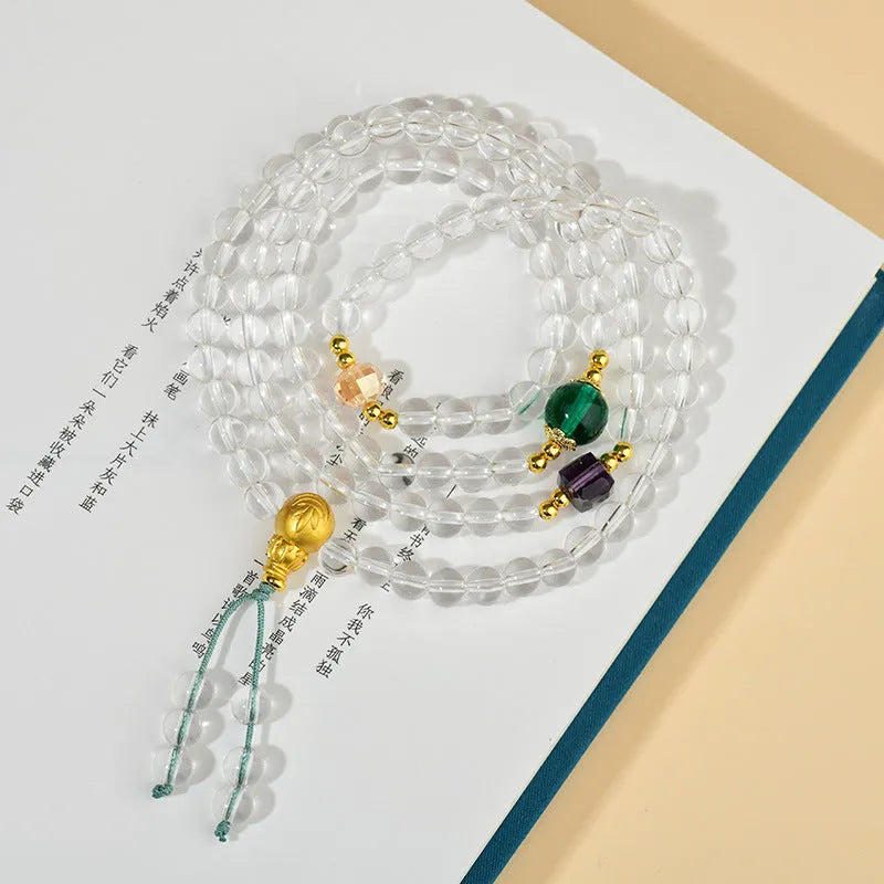 White crystal 108-bead rosary necklace and matching bracelet set on a plain background