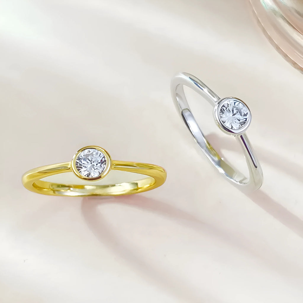 Minimalist crown-shaped silver ring in gold or platinum finish, shown in a simple setting.