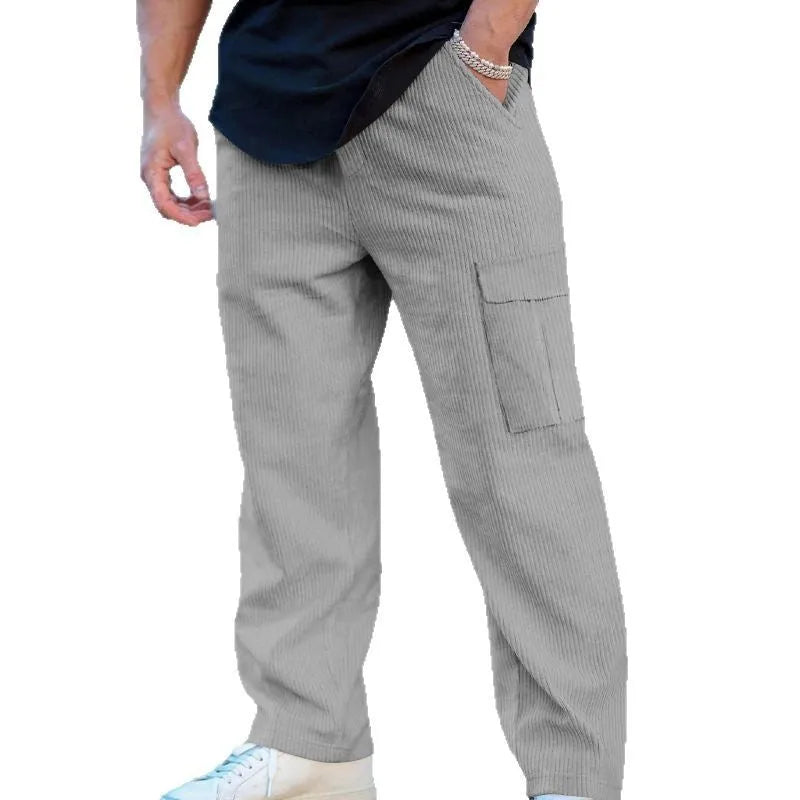 Man wearing navy blue loose-fit corduroy cargo trousers with a drawstring waist.