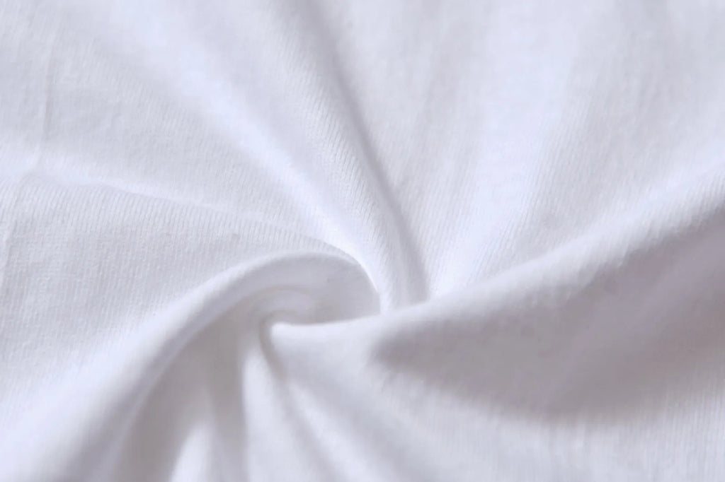 White cotton T-shirt overalls with a round neck and short sleeves, shown in a loose pullover style.