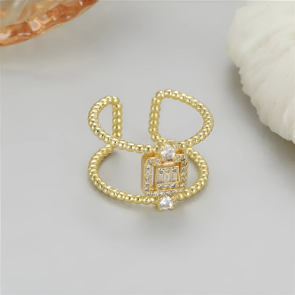 Gold-coloured adjustable open ring with a U-shaped asymmetric design on a hand.