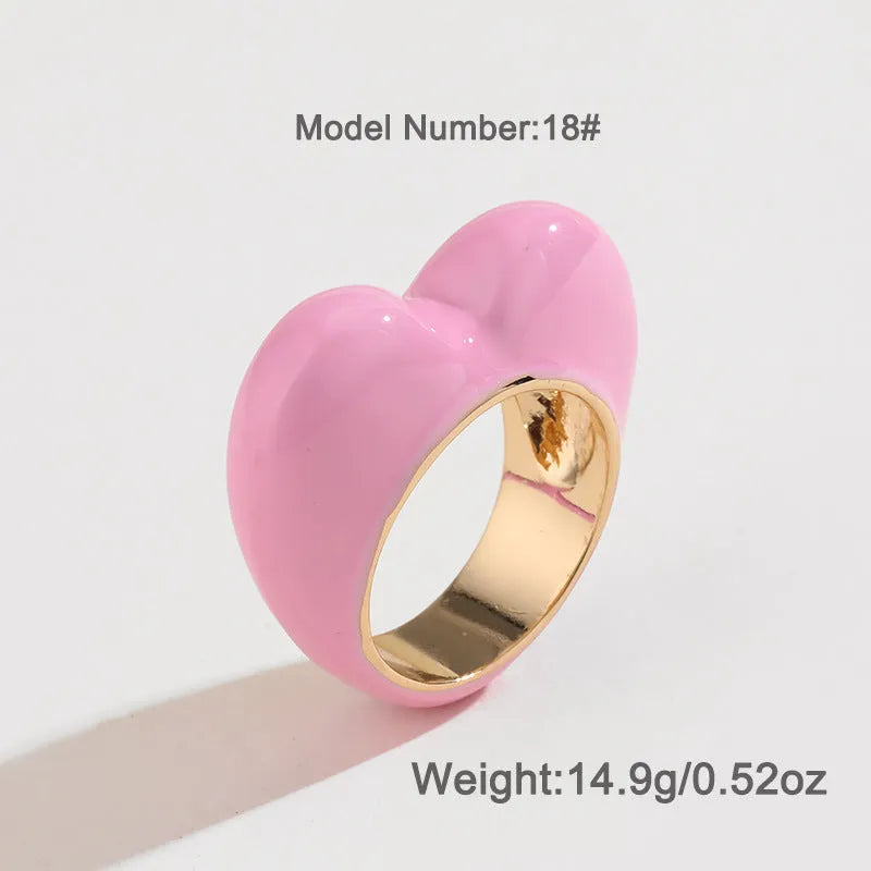 Colourful three-dimensional heart-shaped enamel ring in zinc alloy on a hand.