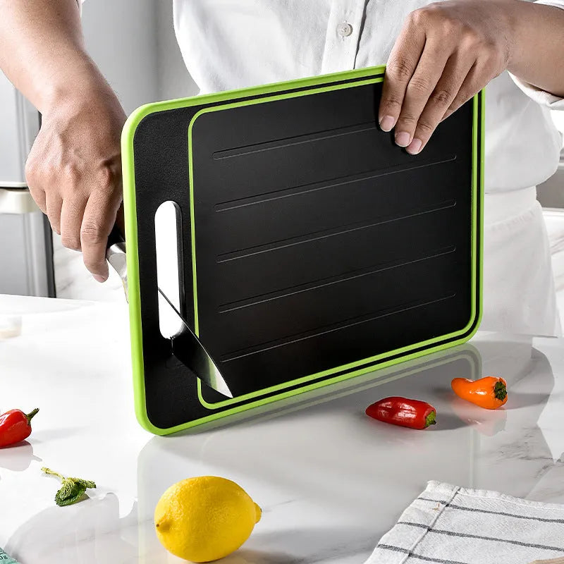 Grey square aluminium cutting board with defrosting side, grinder teeth, and integrated knife sharpener.