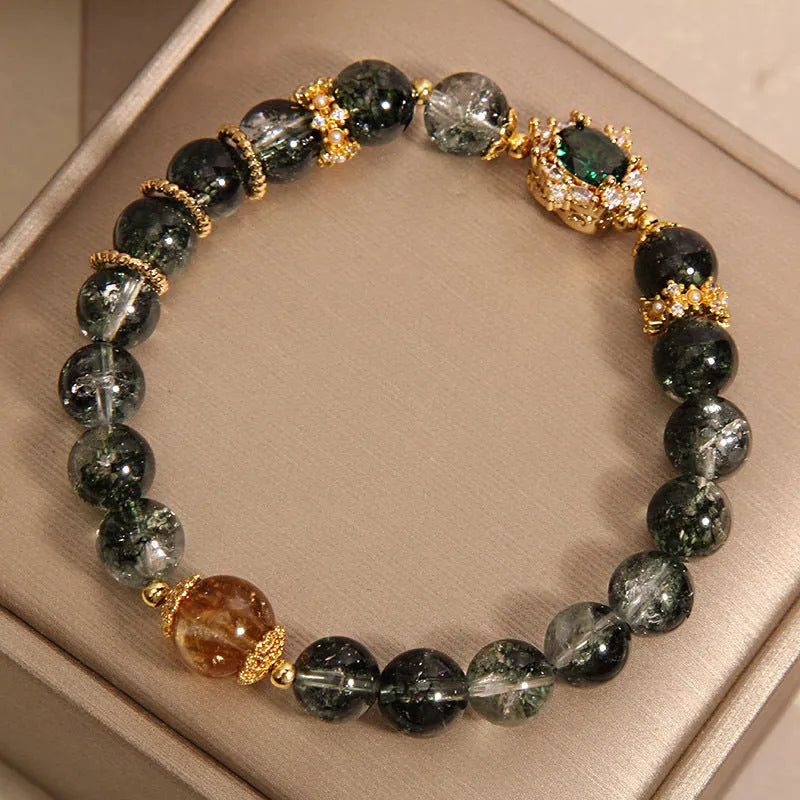 Gold rutilated quartz bracelet with green phantom quartz and ruby quartz crystal beads, pearl accents, and gold-plated detailing