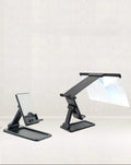 Black foldable mobile phone screen magnifier with detachable shading holder on a desktop.