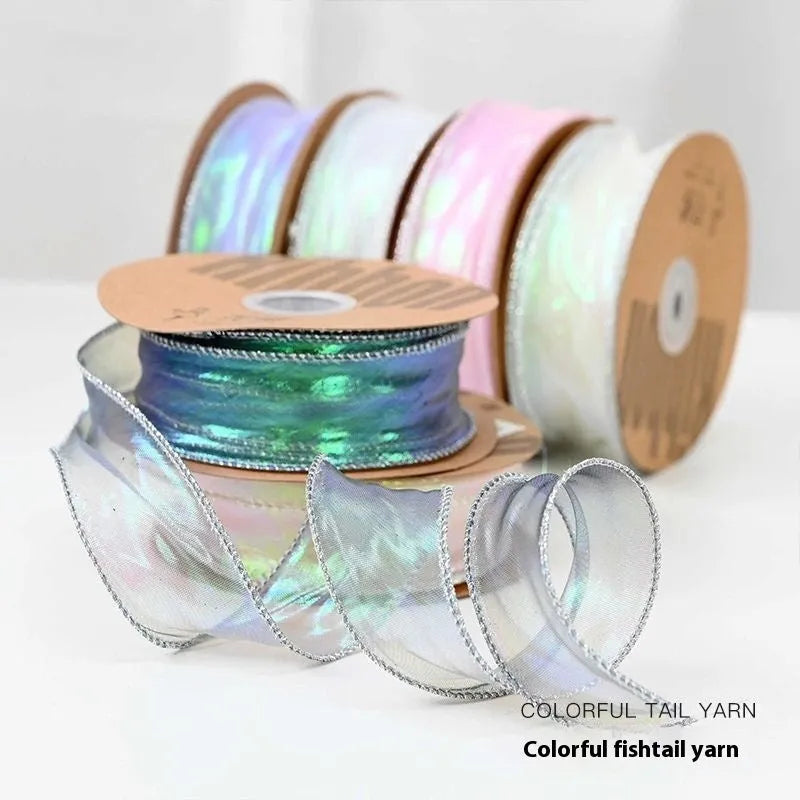 Roll of colourful fishtail yarn mesh ribbon showing its textured, wavy edge, with a colour selection including pink, yellow, and blue.