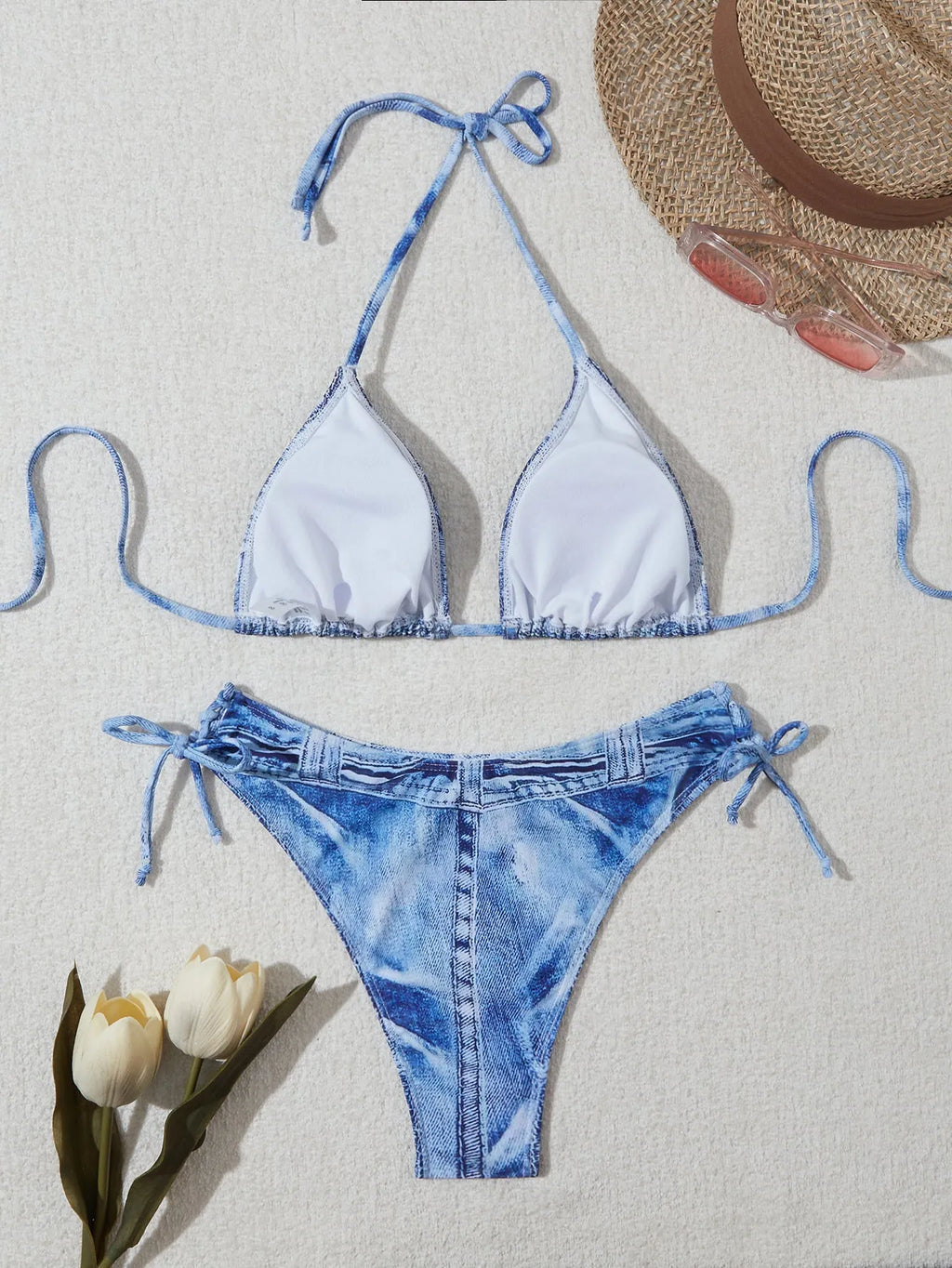 Denim blue printed women's two-piece bikini with thin straps, laid flat.