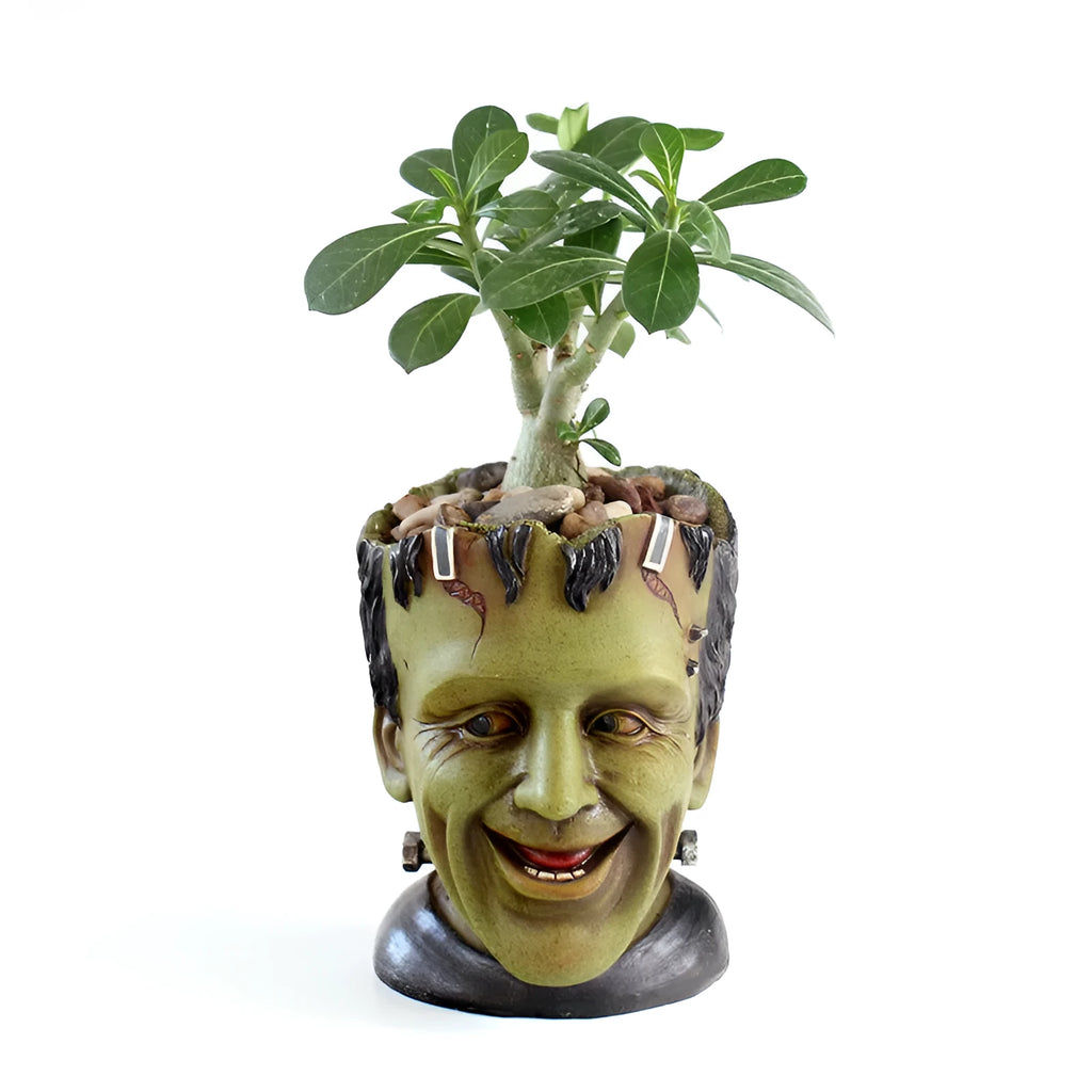 Green Man resin flower pot with sculptural relief detail on white desktop