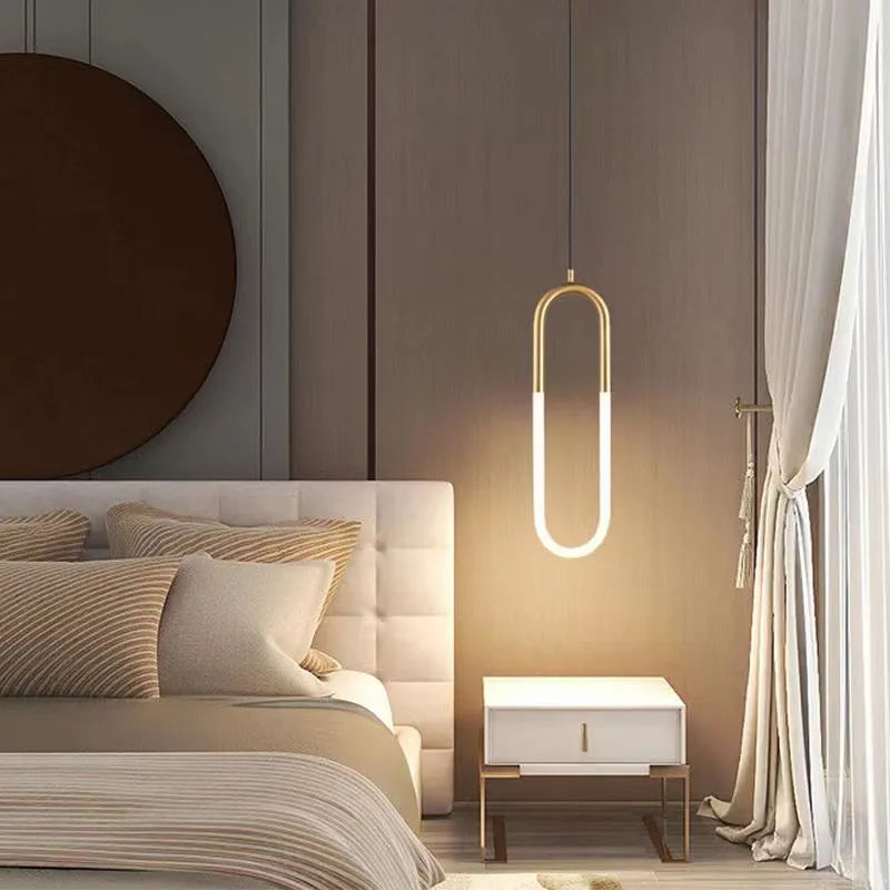 Compact Nordic minimalist U-shaped white pendant light with fabric cord, shown mounted beside a bed.