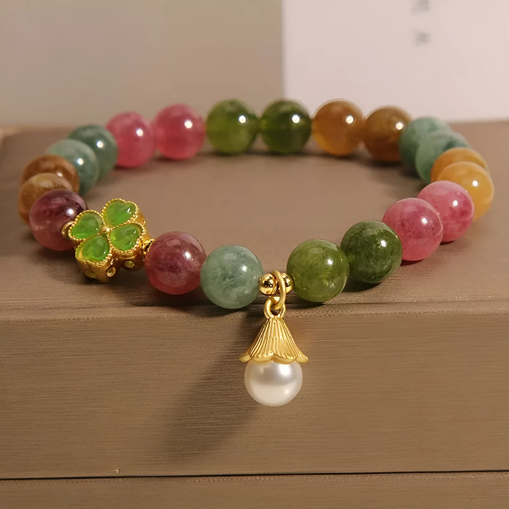 Women's silver-tone bracelet with a drop-shaped four-leaf clover pearl charm and colourful tourmaline stones on a geometric link band.