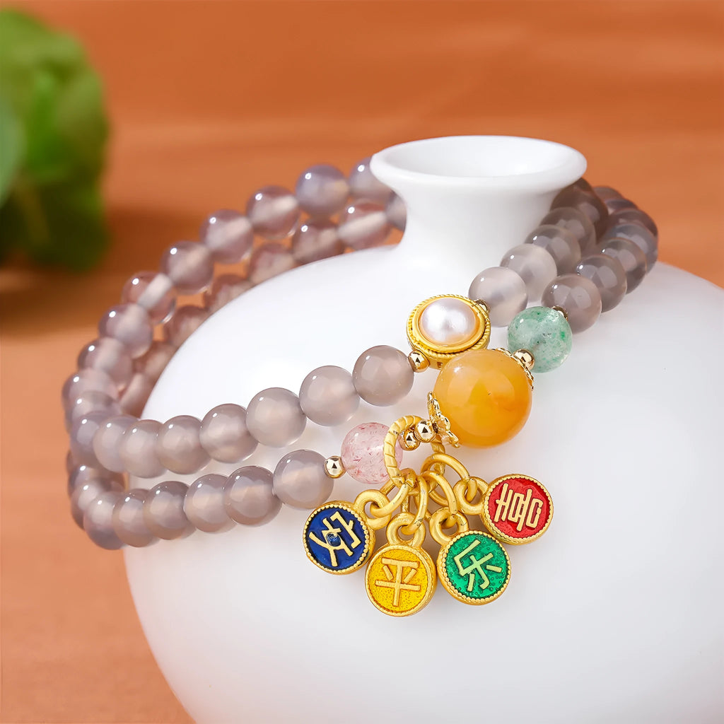Close-up of a grey agate two-circle women's bracelet with a stainless steel clasp on a wrist.
