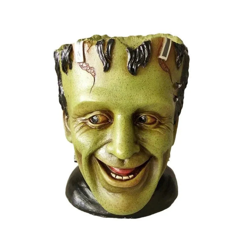 Green Man resin flower pot with sculptural relief detail on white desktop