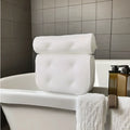 White bathtub pillow with 3D mesh fabric and suction cups on a tub surface.
