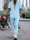 Man wearing a casual short-sleeve shirt and trousers beach suit set in a light blue colour.