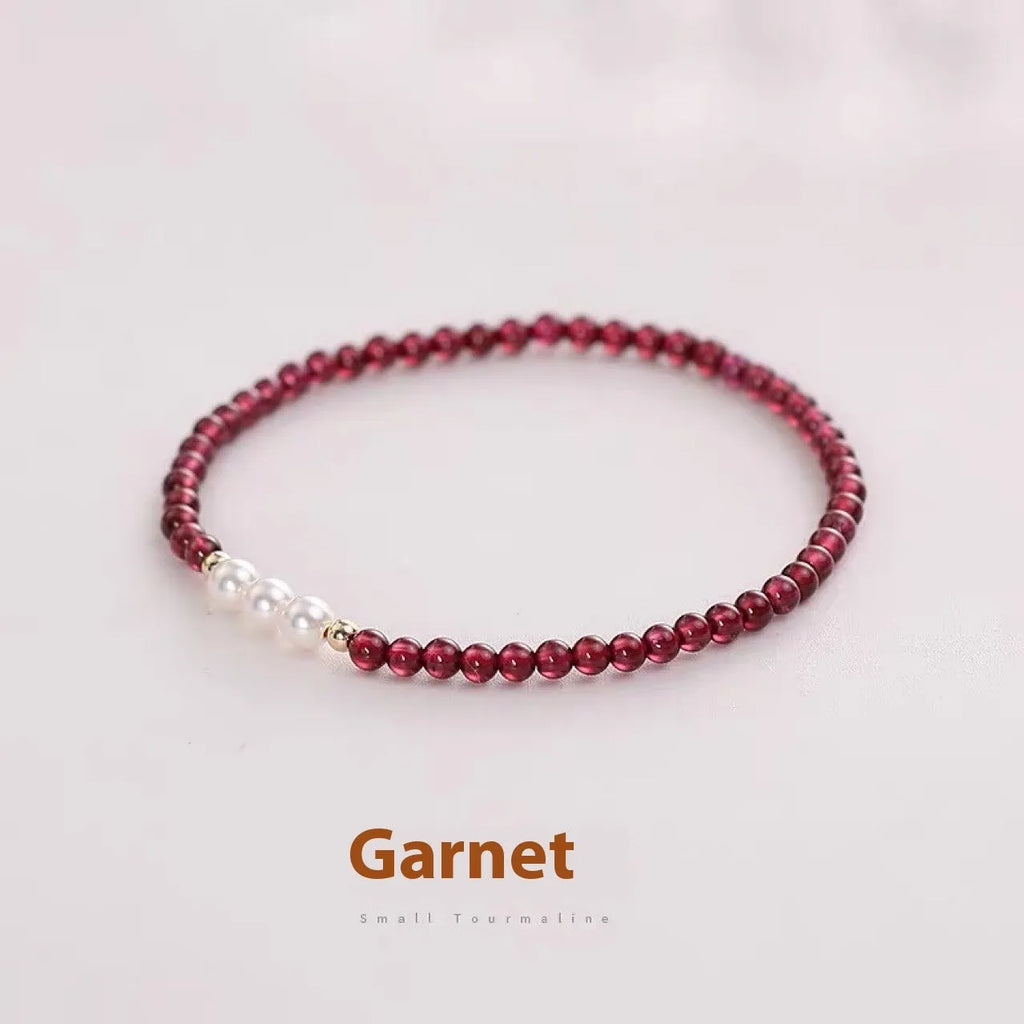 Adjustable women's bracelet with garnet and artificial pearl beads on wrist