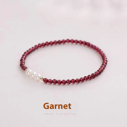 Adjustable women's bracelet with garnet and artificial pearl beads on wrist
