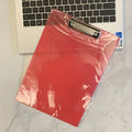 Transparent A4 writing board pad with metal clip holding paper, shown in blue colour option