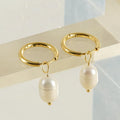 A pair of gold geometric-shaped stainless steel earrings featuring a central pearl and titanium steel posts.