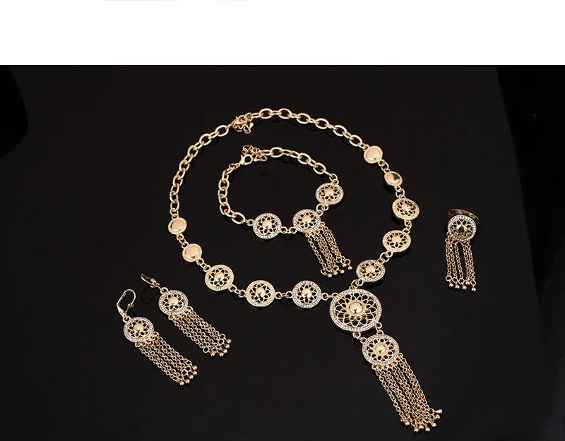 Gold alloy jewellery set with earrings, necklace, and bracelet featuring star and celestial pattern on a light background