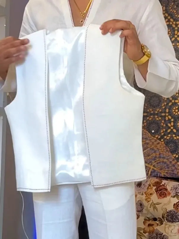 White three-piece outfit comprising V-neck shirt, sleeveless vest and trousers on hanger