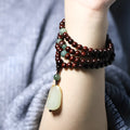 Rosewood bead bracelet with a carved Pterocarpus Santalinus and Hotian Jade stone pendant.