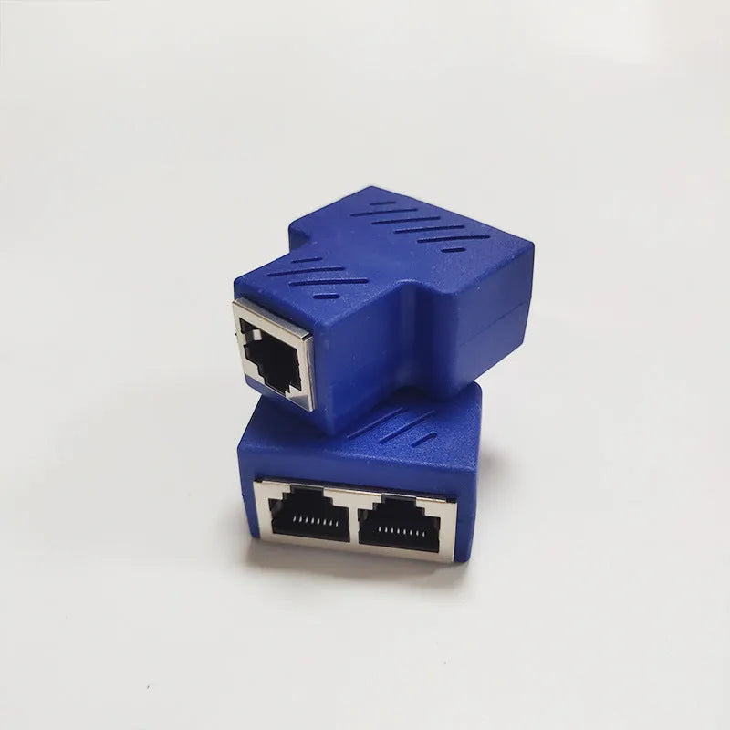 White RJ45 three-way tee network cable splitter adapter on a table.