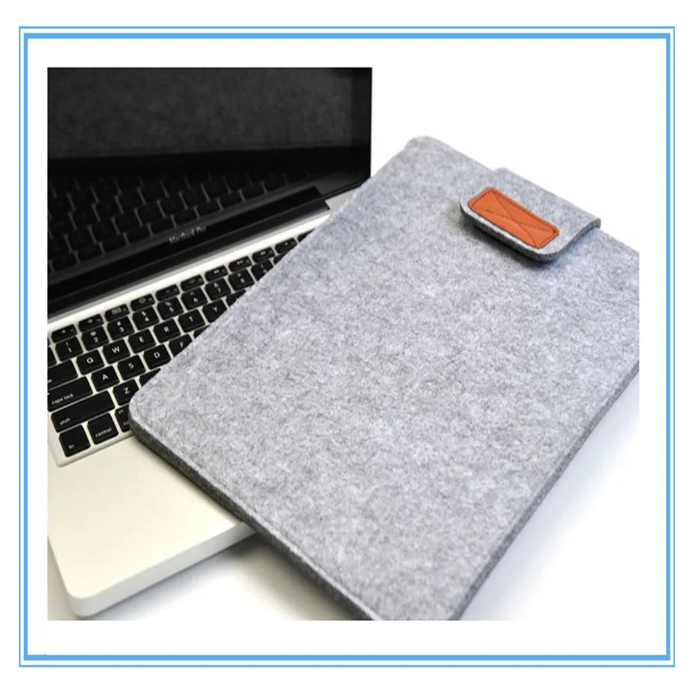 Dark gray felt laptop bag open showing plush lining and tablet compartment
