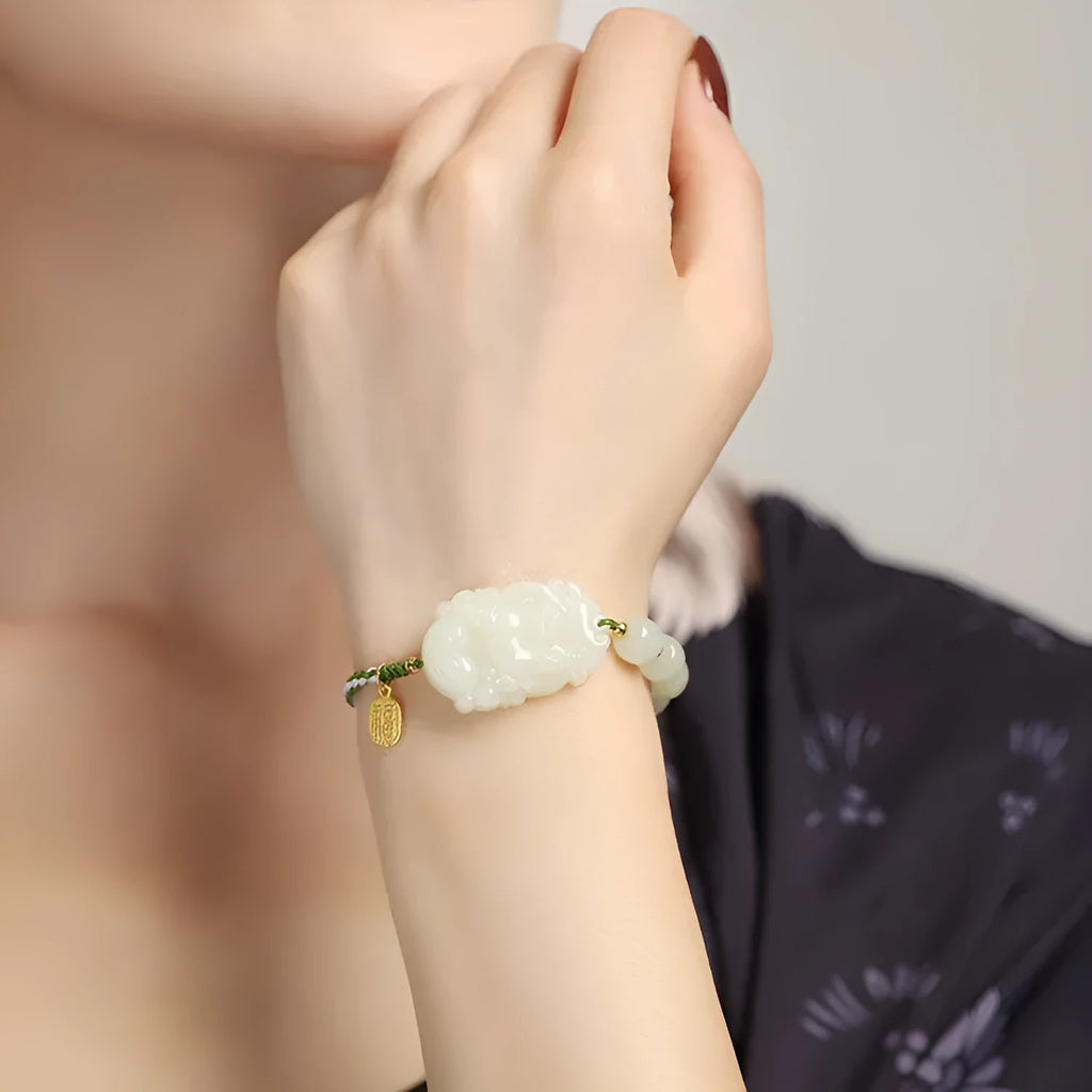 Close-up of a Rabbit zodiac charm Hetian jade bracelet with red rope and S925 silver card.