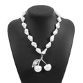 Gold irregular geometric cherry fruit pendant on an adjustable pearl chain necklace for women.